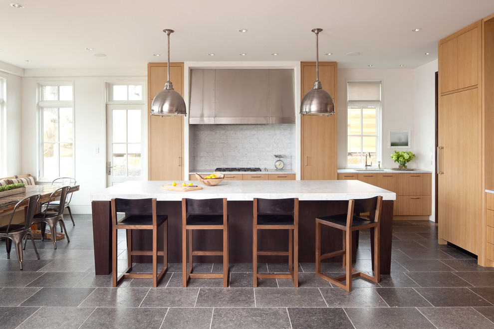 Example of a transitional l-shaped eat-in kitchen design in Minneapolis with flat-panel cabinets, medium tone wood cabinets, white backsplash, paneled appliances, white walls and an island