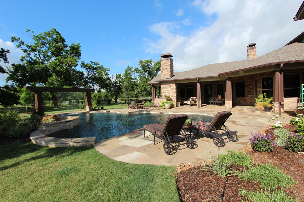 Inspiration for a large rustic backyard tile and custom-shaped pool fountain remodel in Houston