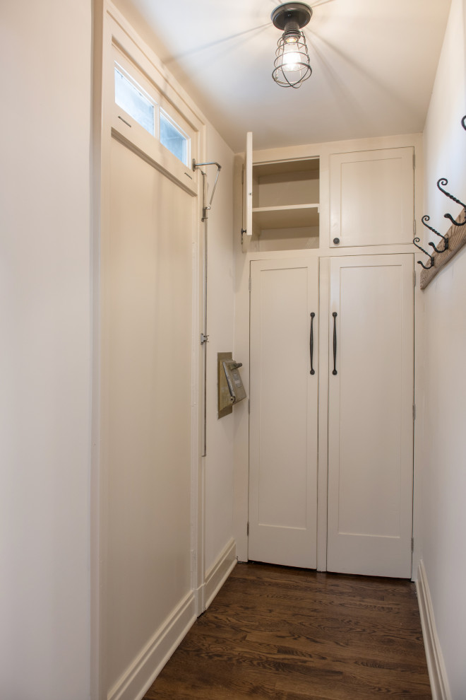 Immagine di una cabina armadio tradizionale di medie dimensioni con ante in stile shaker, ante bianche, parquet scuro e pavimento marrone