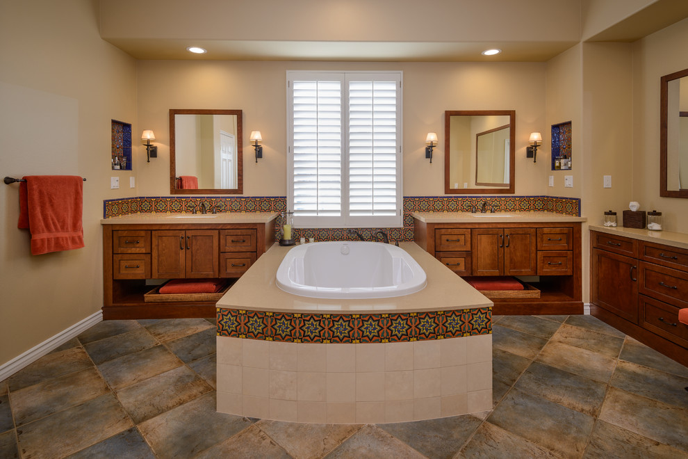 Photo of a large mediterranean master bathroom in Los Angeles with beige walls, porcelain floors, a drop-in tub, an undermount sink, quartzite benchtops, shaker cabinets, medium wood cabinets, beige tile and multi-coloured tile.