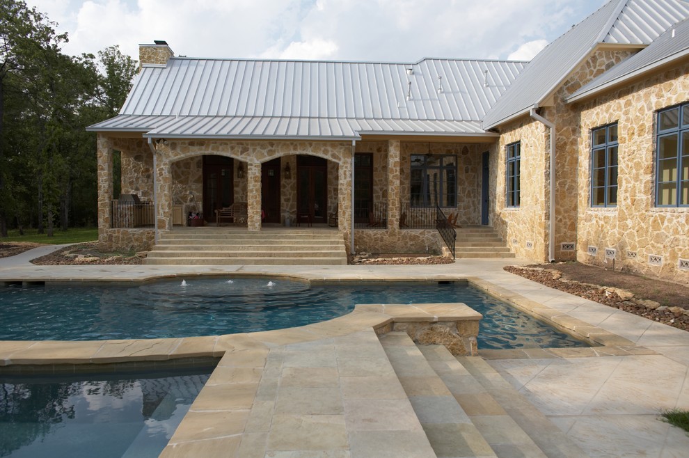 Design ideas for a mid-sized eclectic backyard rectangular lap pool in Houston with a hot tub and natural stone pavers.