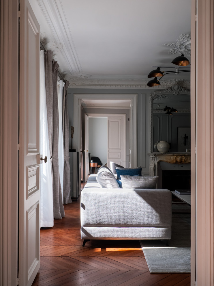 Imagen de dormitorio gris y blanco clásico renovado grande con paredes grises, suelo de madera oscura y todas las chimeneas