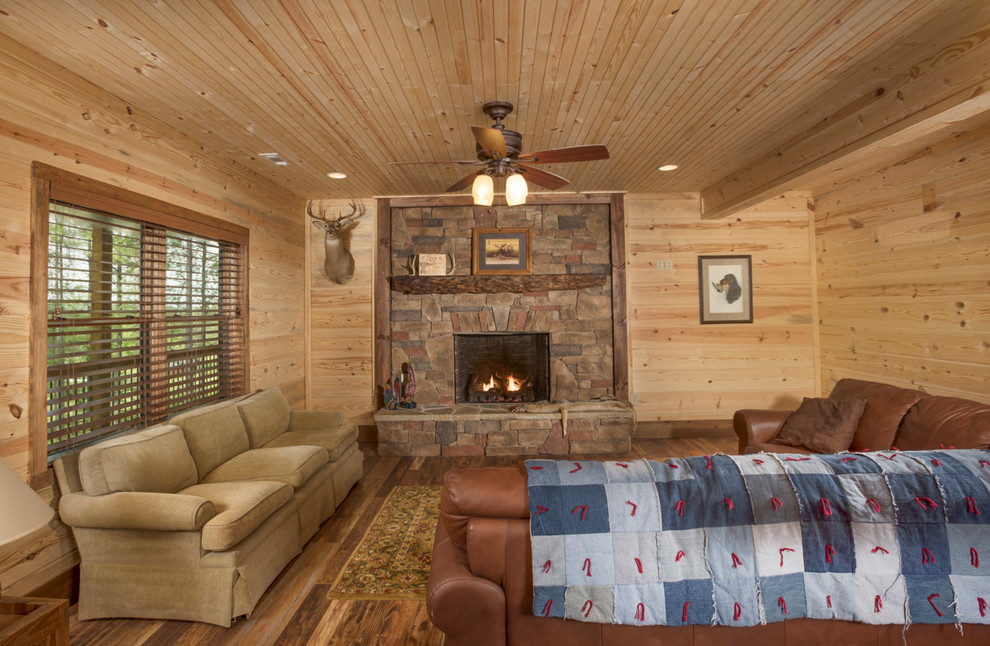 Inspiration for a mid-sized country enclosed family room in Atlanta with brown walls, medium hardwood floors, a standard fireplace, a stone fireplace surround and brown floor.