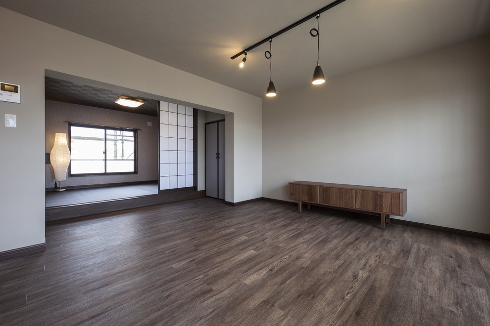 Mittelgroßes, Offenes Asiatisches Wohnzimmer mit grauer Wandfarbe, freistehendem TV, braunem Boden, Tapetendecke und Tapetenwänden in Sonstige