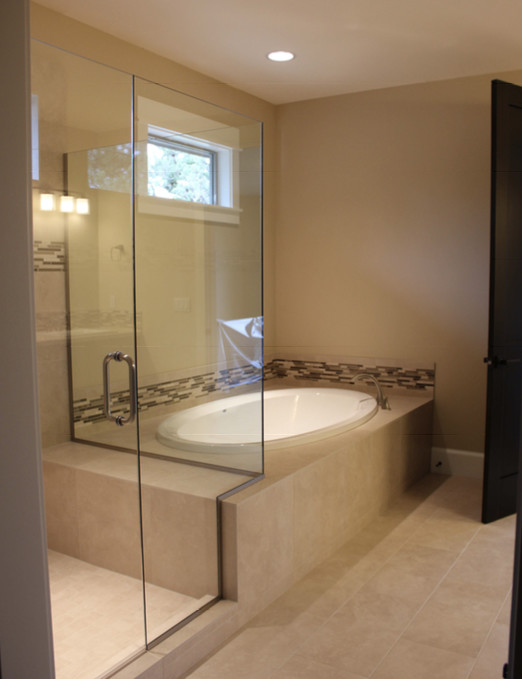 Large transitional master multicolored tile and matchstick tile travertine floor and beige floor drop-in bathtub photo with beige walls and a hinged shower door