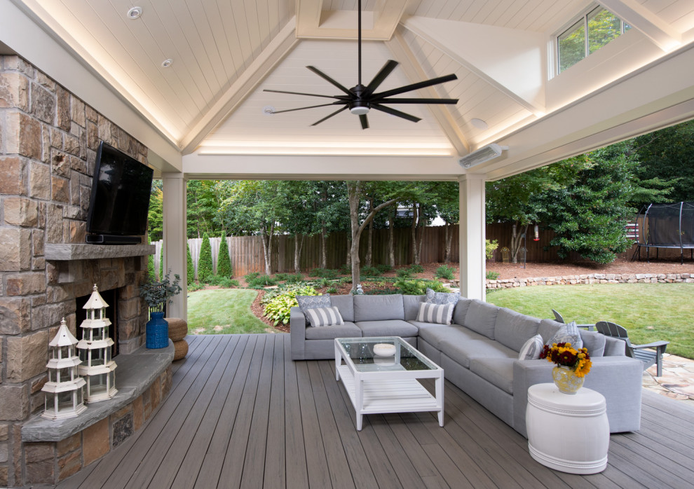 Inspiration for a large classic back veranda in Atlanta with natural stone paving and a fireplace.