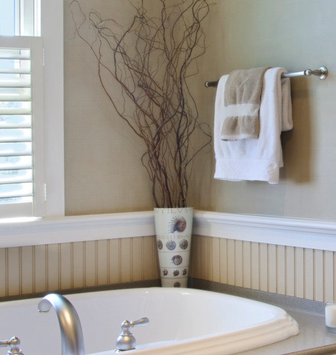Example of a transitional drop-in bathtub design in New York with beaded inset cabinets, beige cabinets and beige walls