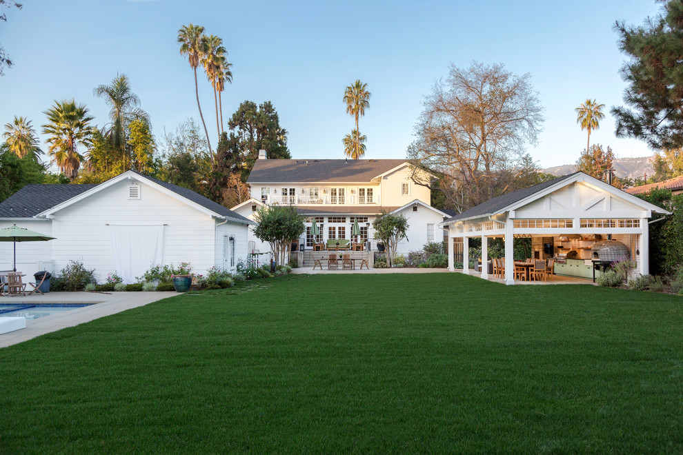 Traditional two-storey white house exterior in Los Angeles with a gable roof and a shingle roof.