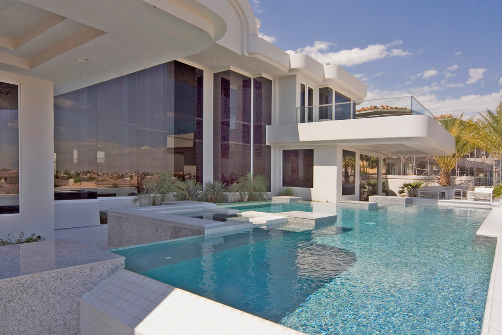 Design ideas for a large modern backyard custom-shaped pool in Las Vegas with a hot tub.