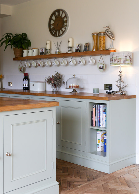 Cette image montre une cuisine ouverte rustique avec un placard à porte shaker, des portes de placard grises, îlot et un plan de travail marron.