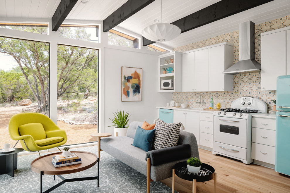 Small retro kitchen/diner in Austin with a built-in sink, flat-panel cabinets, white cabinets, engineered stone countertops, white splashback, cement tile splashback, stainless steel appliances, medium hardwood flooring, an island, beige floors, white worktops and a wood ceiling.
