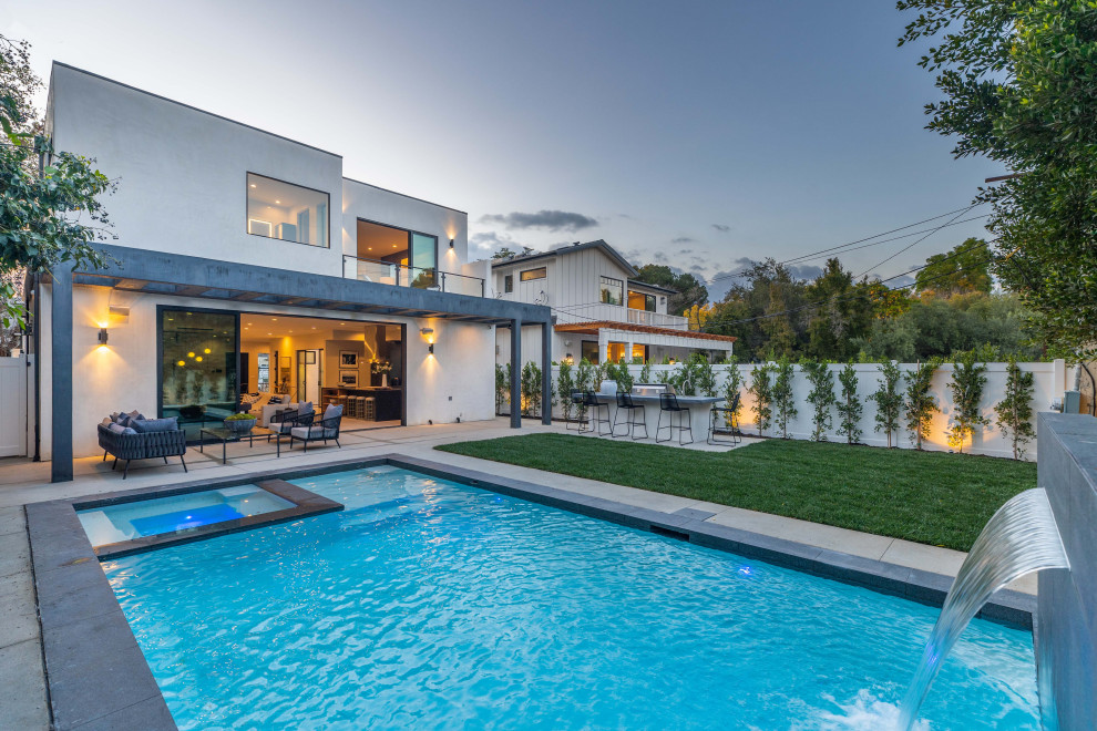 Großer Moderner Pool hinter dem Haus in rechteckiger Form mit Grillplatz, Wasserspiel und Betonplatten in Los Angeles