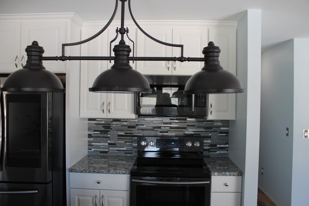 Inspiration for a mid-sized transitional u-shaped dark wood floor and brown floor kitchen remodel with an undermount sink, raised-panel cabinets, white cabinets, granite countertops, multicolored backsplash, matchstick tile backsplash, stainless steel appliances and an island