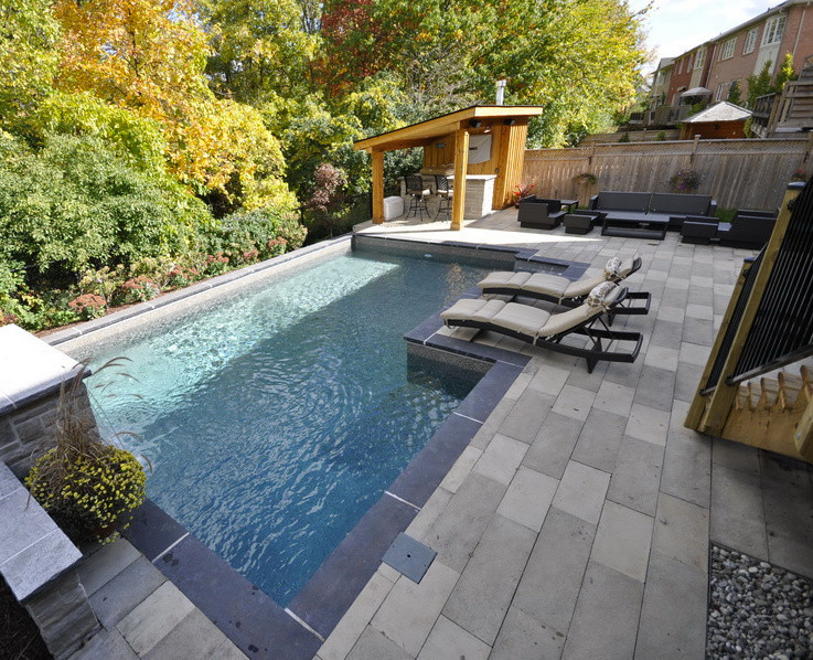 Inspiration for a large traditional backyard custom-shaped pool in Toronto with a water feature.