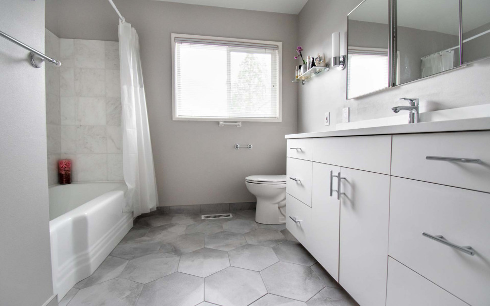 Inspiration for a mid-sized transitional 3/4 bathroom in Portland with flat-panel cabinets, white cabinets, an alcove tub, a shower/bathtub combo, a two-piece toilet, white tile, ceramic tile, grey walls, ceramic floors, an undermount sink, engineered quartz benchtops, grey floor, a shower curtain, white benchtops, a single vanity and a built-in vanity.