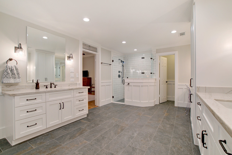 Design ideas for a country master bathroom in Houston with shaker cabinets, white cabinets, a freestanding tub, a corner shower, a one-piece toilet, white tile, ceramic tile, white walls, porcelain floors, an undermount sink, quartzite benchtops, grey floor, a hinged shower door and white benchtops.