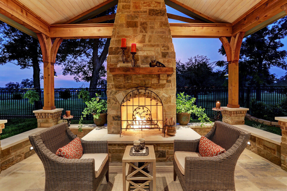 This is an example of a country patio in Houston with natural stone pavers and with fireplace.