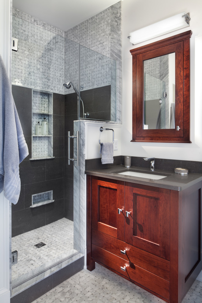 Photo of a beach style bathroom in DC Metro with an undermount sink, shaker cabinets, dark wood cabinets, an alcove shower, gray tile, white walls, mosaic tile floors and grey benchtops.