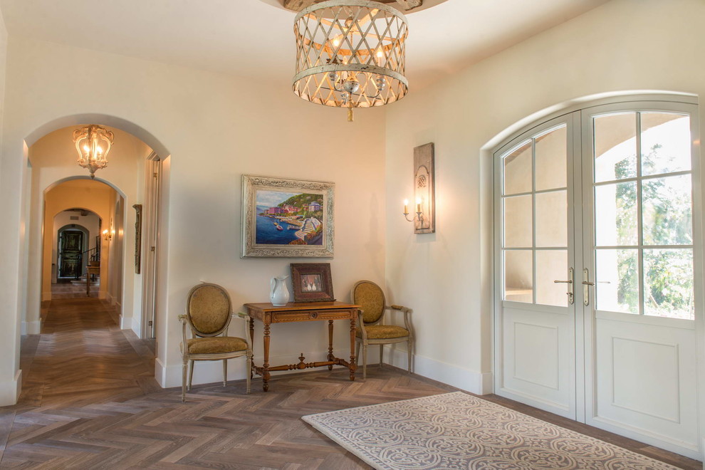 Inspiration for a large mediterranean entry hall in Other with beige walls, medium hardwood floors, a double front door and a white front door.