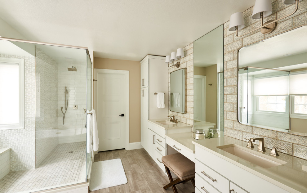 На фото: главная ванная комната среднего размера в классическом стиле с плоскими фасадами, белыми фасадами, отдельно стоящей ванной, открытым душем, раздельным унитазом, разноцветной плиткой, бежевыми стенами, полом из керамической плитки, врезной раковиной, столешницей из искусственного кварца, коричневым полом, душем с распашными дверями, бежевой столешницей, сиденьем для душа, тумбой под две раковины и встроенной тумбой