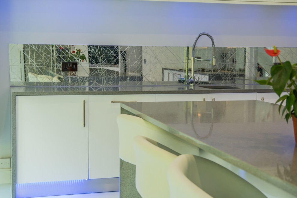 Design ideas for a modern kitchen in Hertfordshire with mirror splashback.