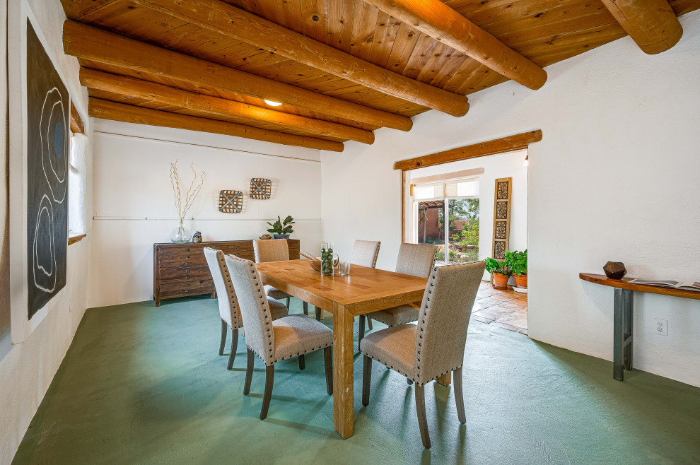 Mid-sized open plan dining in Other with white walls, concrete floors, no fireplace, green floor and exposed beam.