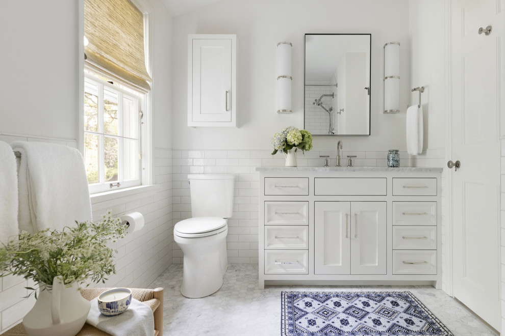 Пример оригинального дизайна: ванная комната в классическом стиле с белыми фасадами, белой плиткой, белыми стенами, серой столешницей, тумбой под одну раковину и встроенной тумбой