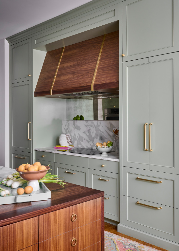 Example of a mid-sized transitional galley medium tone wood floor and brown floor open concept kitchen design in Atlanta with an undermount sink, recessed-panel cabinets, green cabinets, marble countertops, white backsplash, marble backsplash, paneled appliances, an island and white countertops