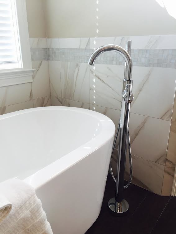 Mid-sized transitional master porcelain tile and white tile porcelain tile and brown floor corner shower photo with an undermount sink, recessed-panel cabinets, white cabinets, a one-piece toilet, beige walls, granite countertops, a hinged shower door and multicolored countertops