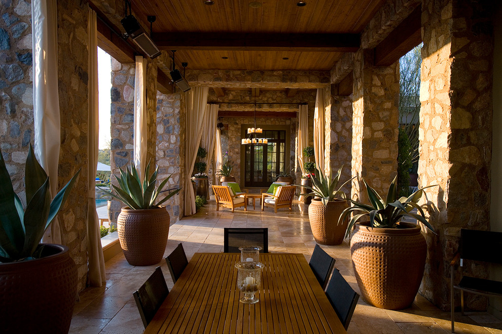 Photo of a mediterranean patio in Phoenix with a roof extension.