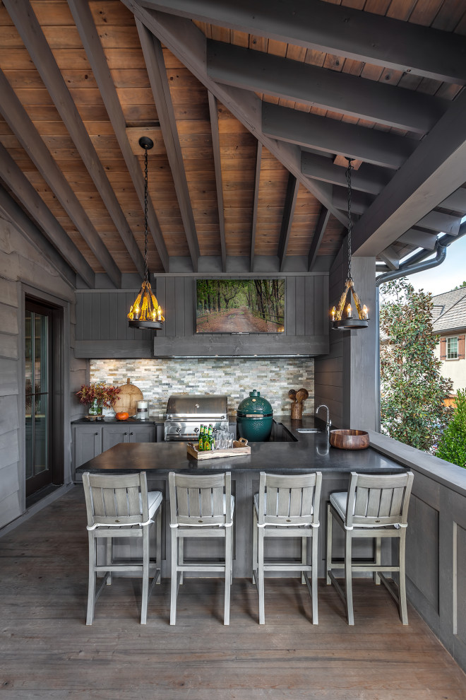 Diseño de terraza rústica en anexo de casas con cocina exterior, entablado y barandilla de madera