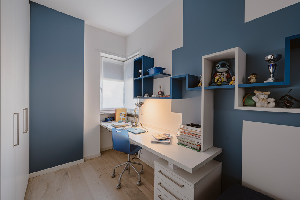 This is an example of a small modern kids' room for boys in Milan with multi-coloured walls, light hardwood floors and beige floor.