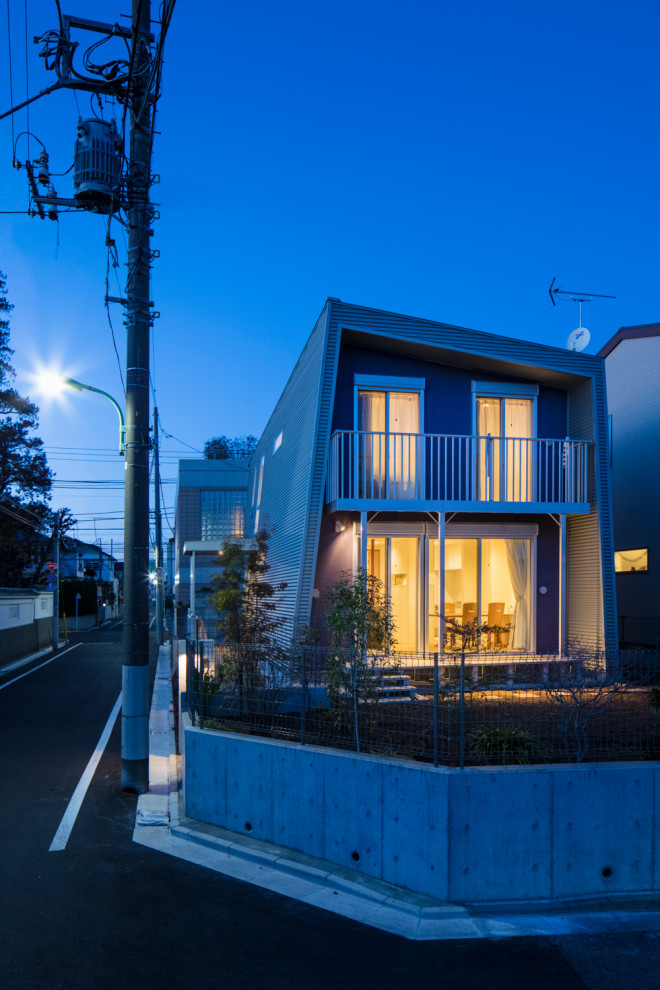 Mid-sized modern two-storey purple house exterior in Tokyo with metal siding, a shed roof and a metal roof.