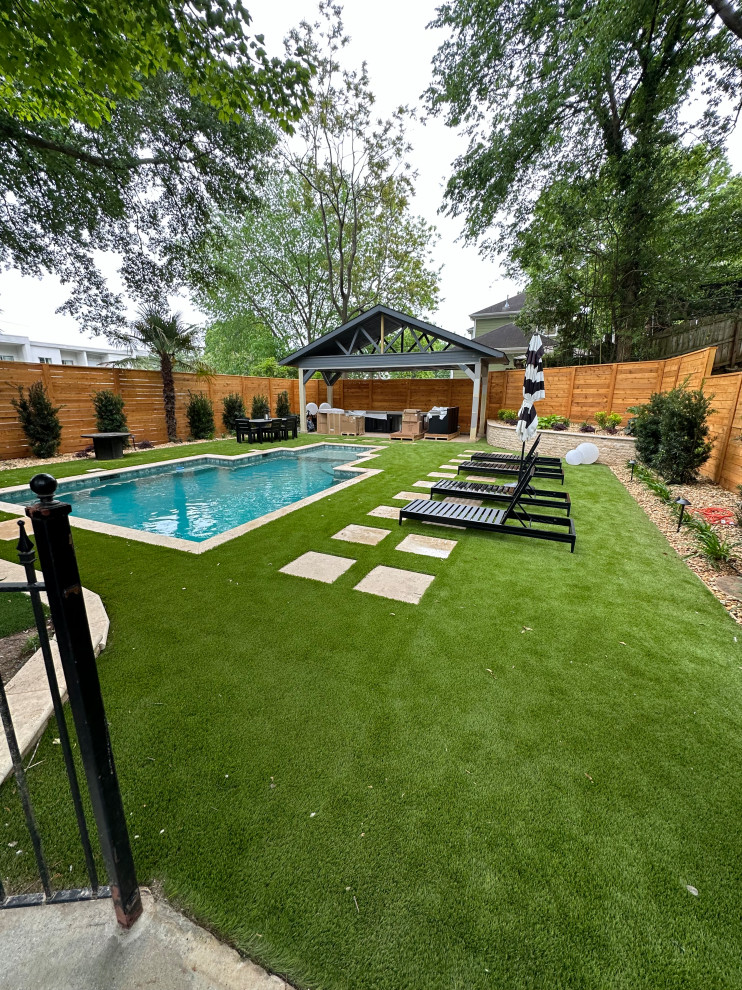 Photo of a mid-sized modern backyard rectangular natural pool in Other with a hot tub and decking.
