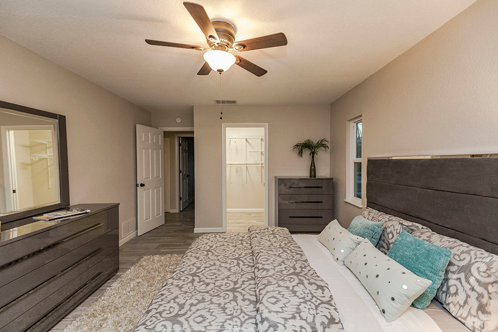 Design ideas for a mid-sized contemporary master bedroom in Tampa with grey walls, laminate floors, no fireplace and grey floor.