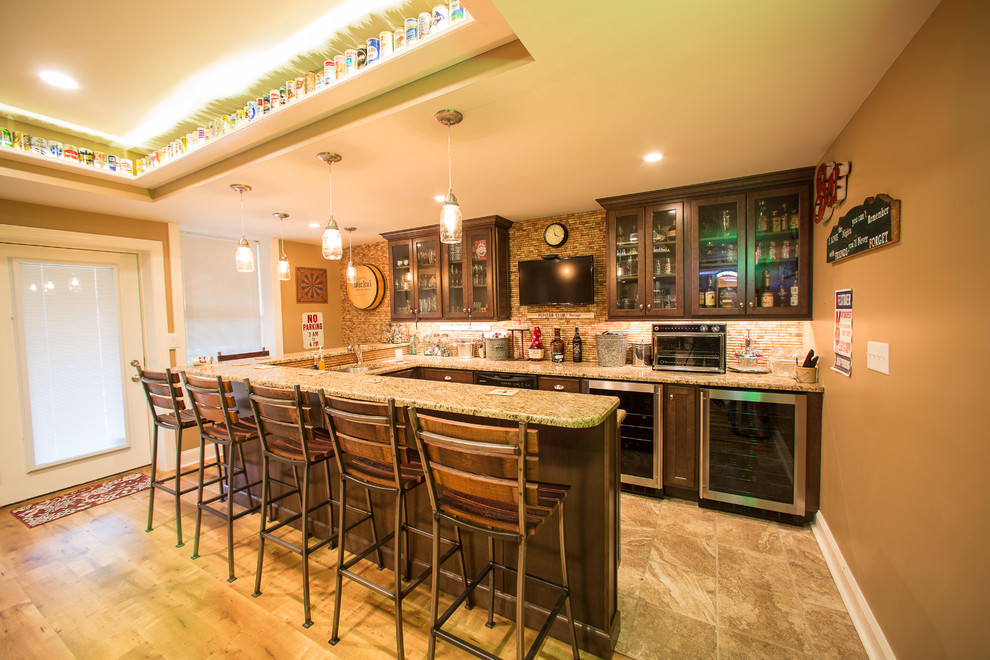 This is an example of a large country u-shaped seated home bar in Philadelphia with an undermount sink, shaker cabinets, dark wood cabinets, granite benchtops, brown splashback, matchstick tile splashback, ceramic floors and brown floor.