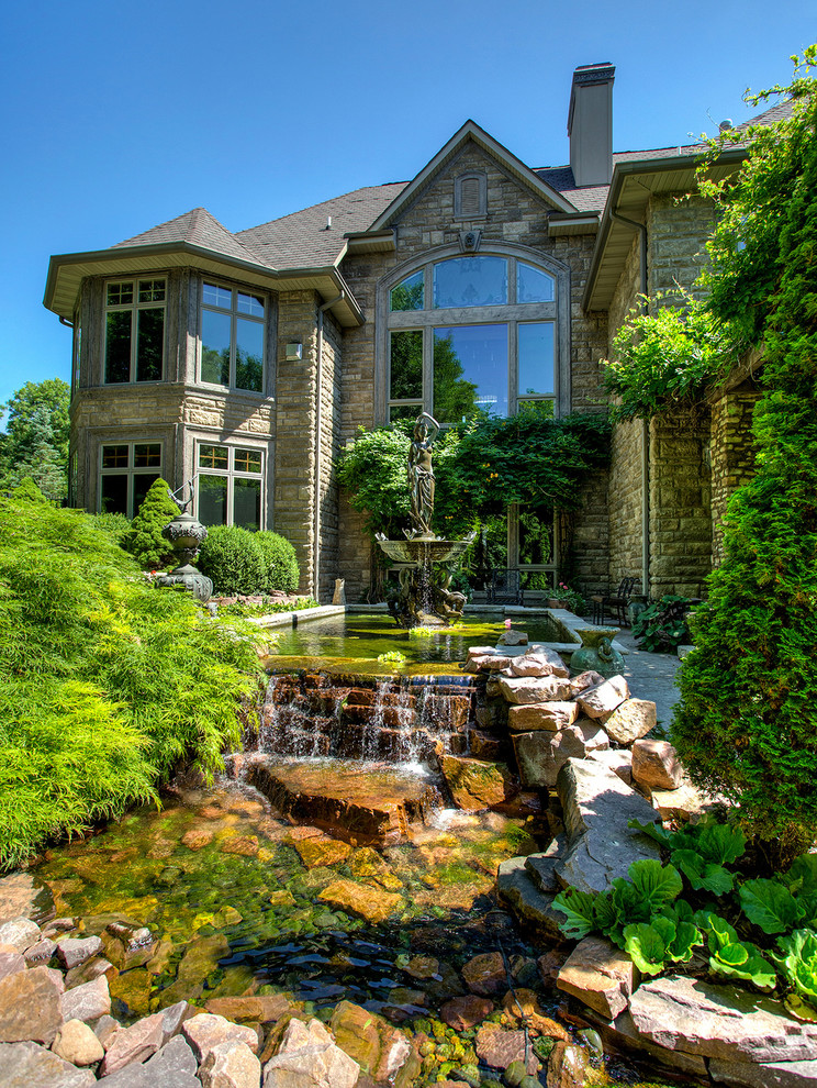 Design ideas for a traditional garden in Other with a water feature and natural stone pavers.