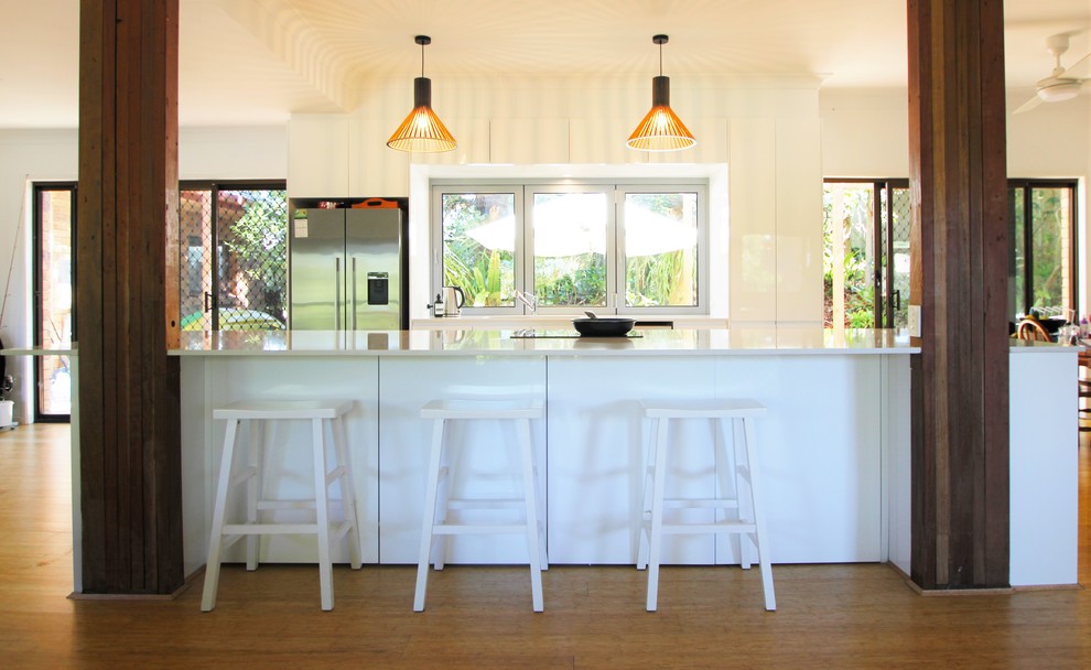 Inspiration for a mid-sized beach style galley eat-in kitchen in Sunshine Coast with an undermount sink, white cabinets, quartz benchtops, stainless steel appliances, with island and white benchtop.