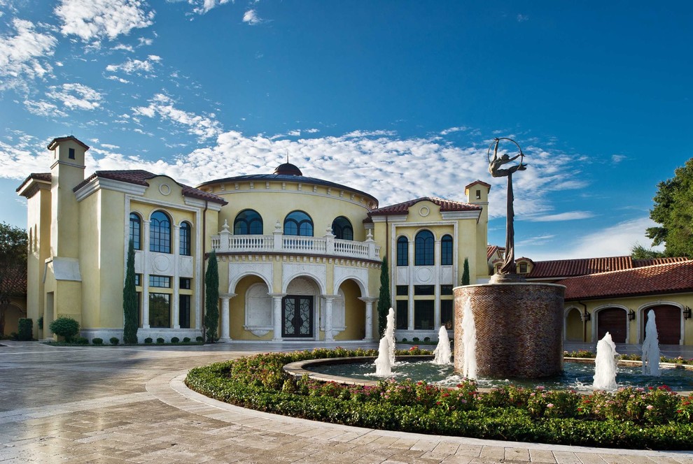 Inspiration for a large traditional two-storey stucco yellow exterior in Miami.
