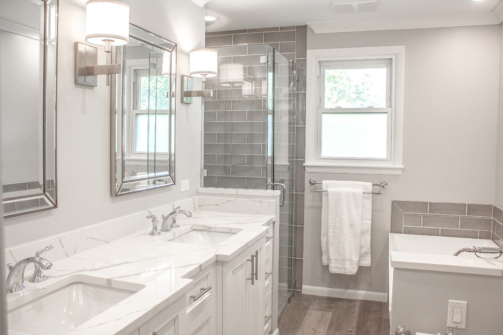 This is an example of a mid-sized modern 3/4 bathroom in Other with beaded inset cabinets, white cabinets, a freestanding tub, grey walls, plywood floors, marble benchtops, grey floor and white benchtops.