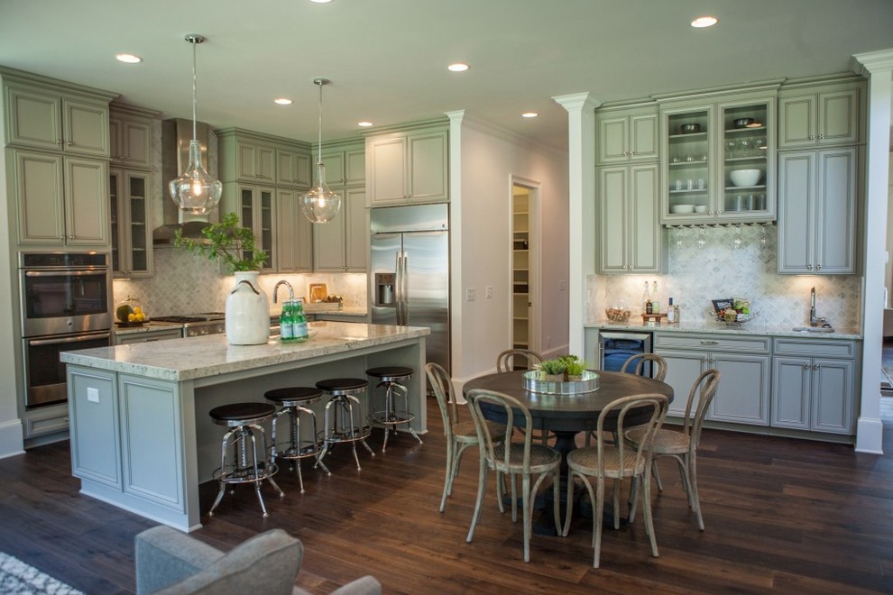 Photo of a large traditional single-wall eat-in kitchen in Atlanta with a farmhouse sink, louvered cabinets, light wood cabinets, marble benchtops, beige splashback, ceramic splashback, stainless steel appliances, dark hardwood floors and with island.