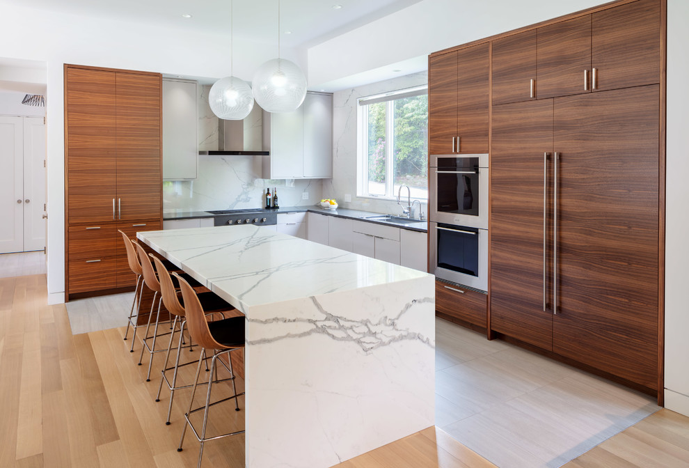 This is an example of a large contemporary l-shaped kitchen in Providence with an undermount sink, flat-panel cabinets, quartz benchtops, stainless steel appliances, ceramic floors, with island, dark wood cabinets, white splashback, stone slab splashback and grey benchtop.