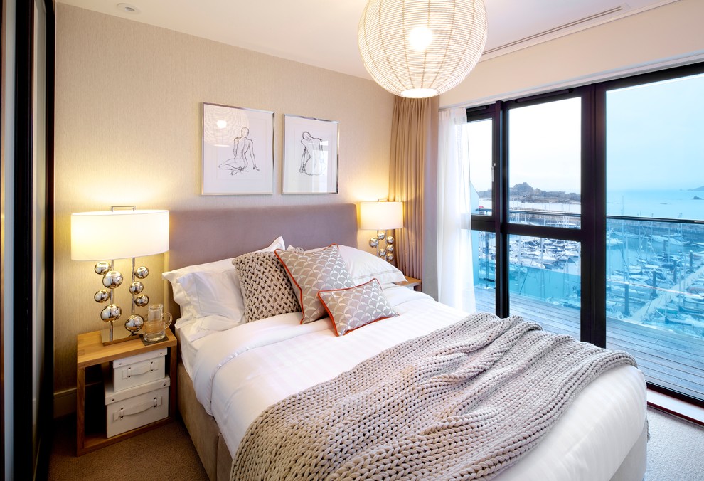 This is an example of a contemporary bedroom in Channel Islands with beige walls and carpet.