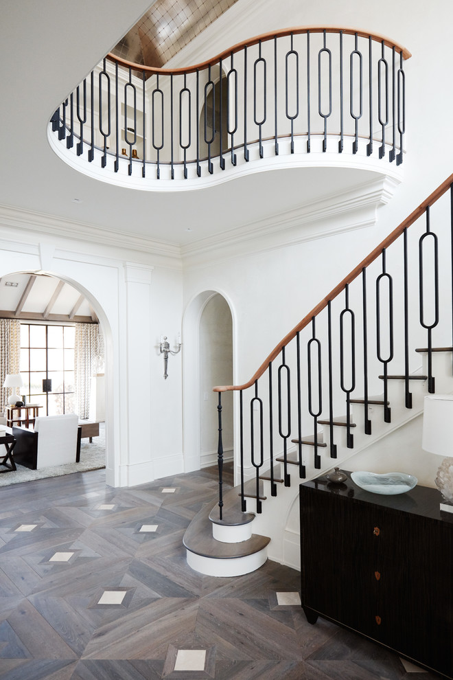 Expansive transitional wood curved staircase in New York with metal risers.