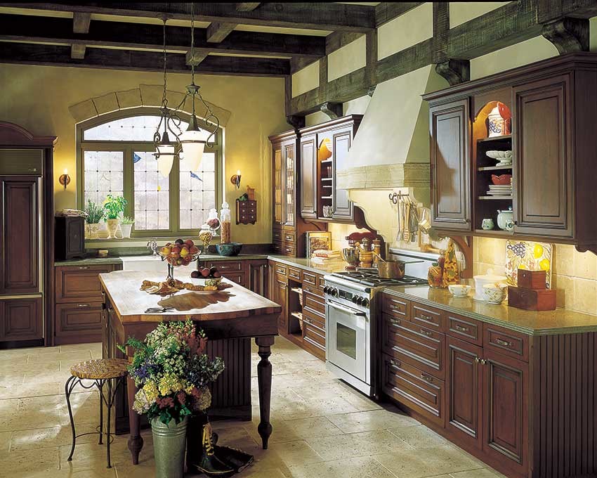 Mid-sized mountain style u-shaped enclosed kitchen photo in Jackson with a farmhouse sink, raised-panel cabinets, dark wood cabinets, granite countertops, beige backsplash, ceramic backsplash, stainless steel appliances and an island