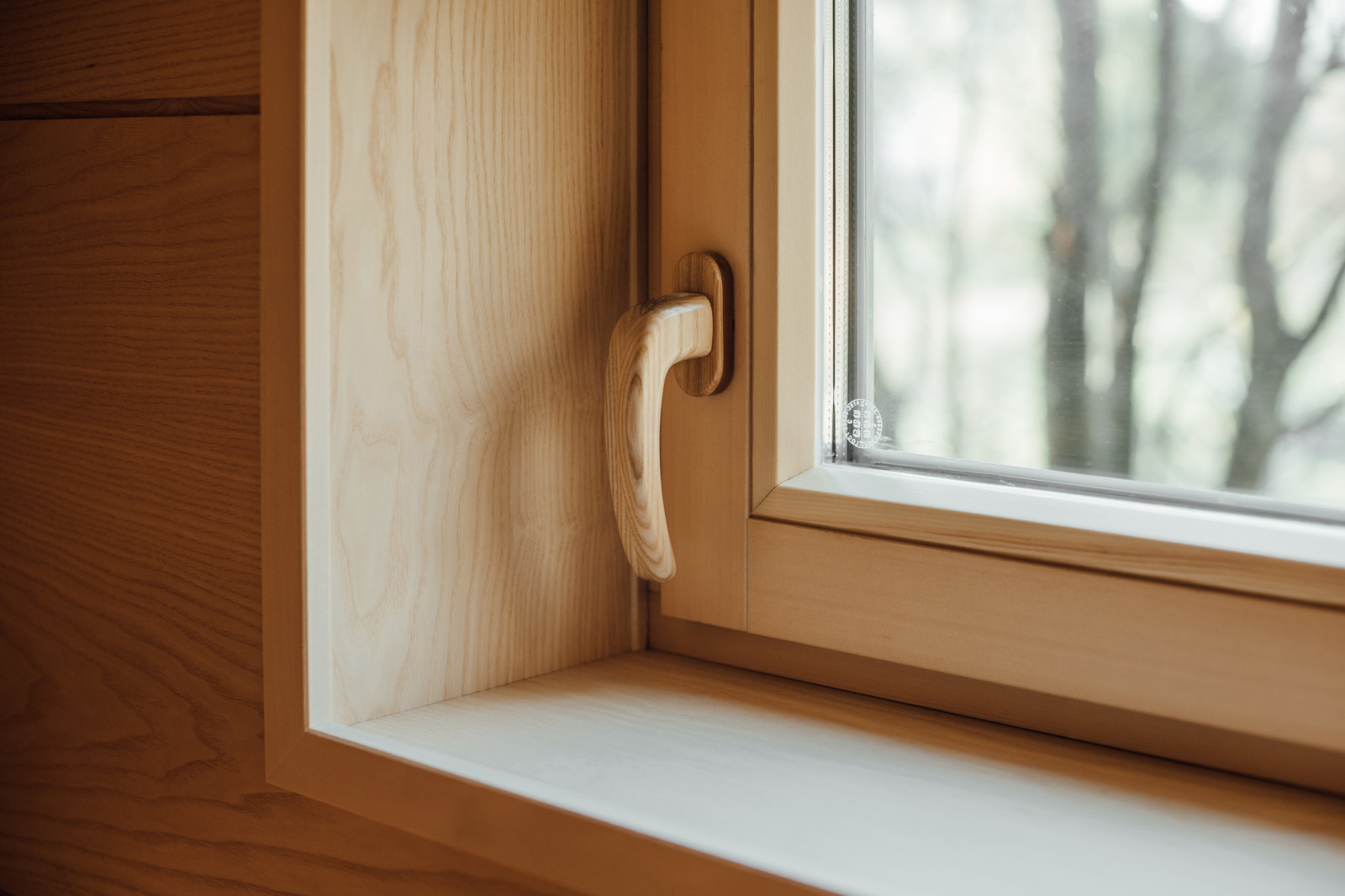 Окно в сауне с деревянной ручкой.