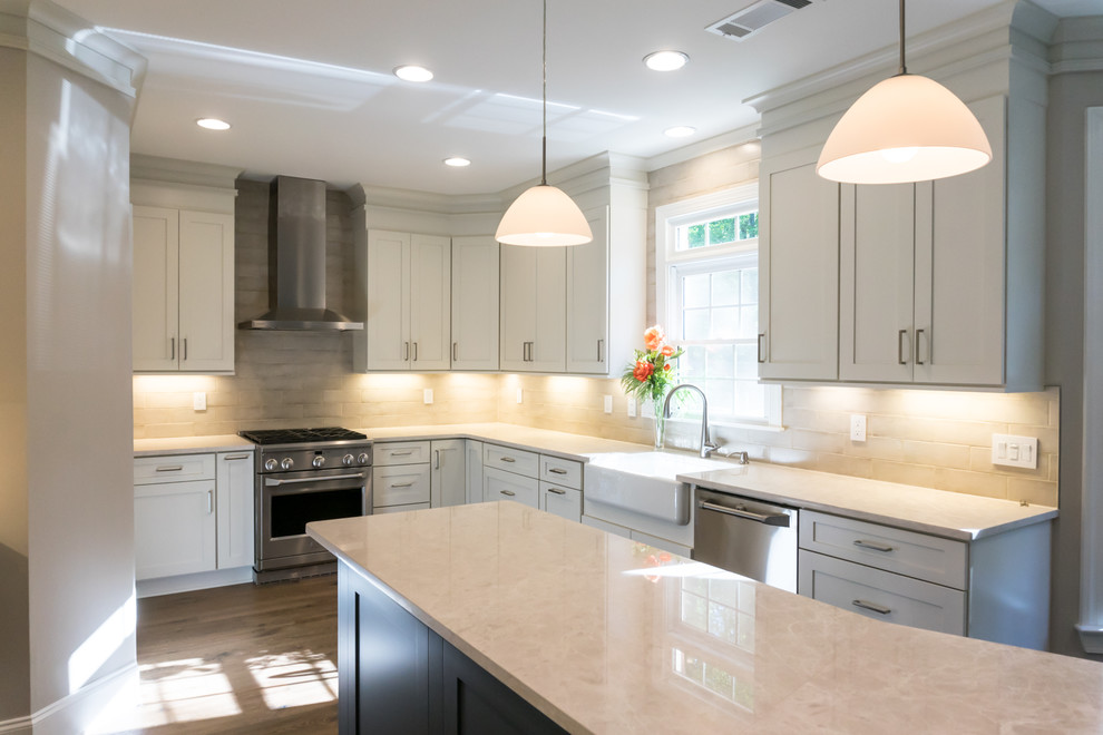 Inspiration for a large transitional u-shaped separate kitchen in Atlanta with a farmhouse sink, shaker cabinets, white cabinets, beige splashback, stainless steel appliances, dark hardwood floors, with island, brown floor, white benchtop, quartz benchtops and cement tile splashback.