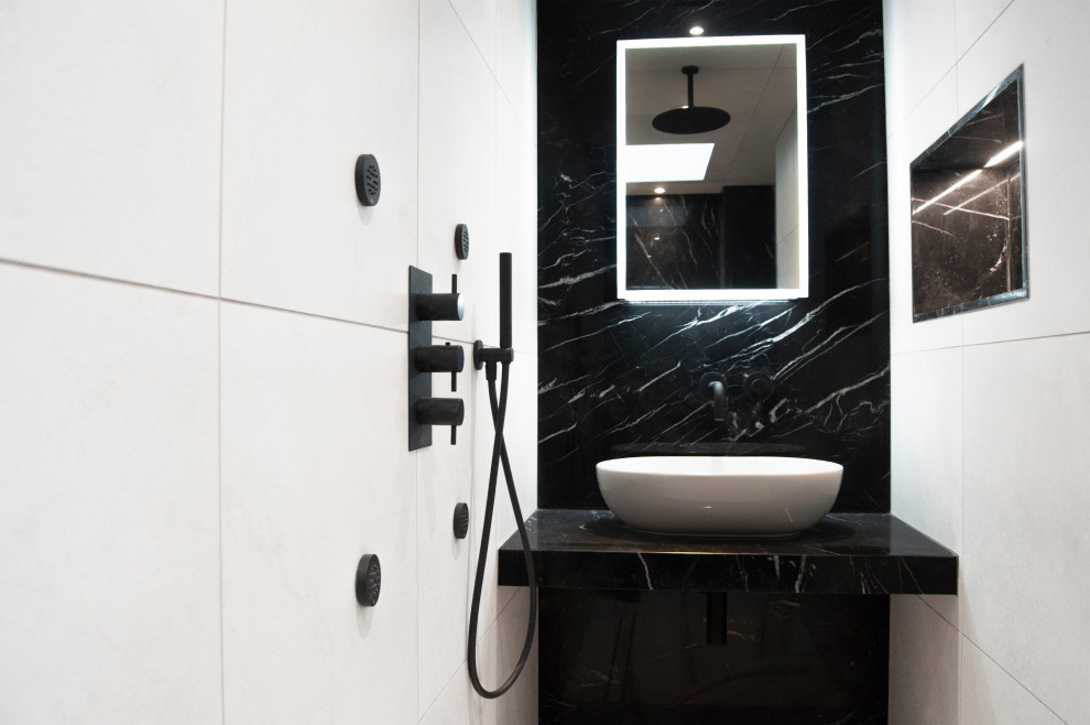 Design ideas for a small modern 3/4 wet room bathroom in London with flat-panel cabinets, black cabinets, a wall-mount toilet, black and white tile, marble, white walls, marble floors, a vessel sink, marble benchtops, white floor, an open shower and black benchtops.