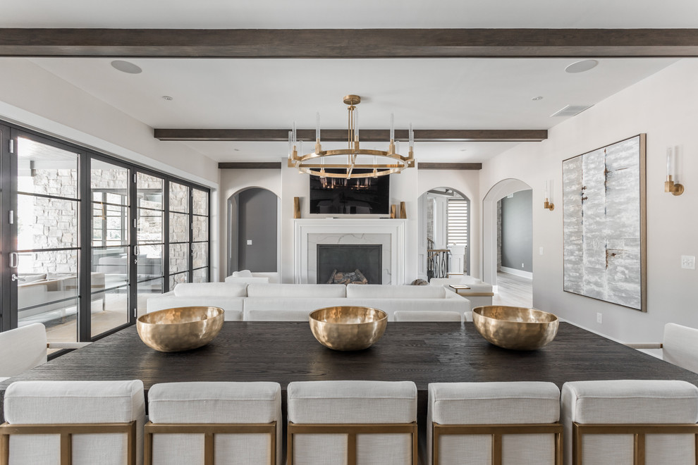 This is an example of an expansive contemporary kitchen/dining combo in Indianapolis with beige walls, medium hardwood floors, a standard fireplace, a tile fireplace surround and brown floor.