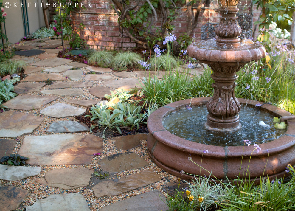 This is an example of a mid-sized traditional shade backyard stone garden path in Los Angeles.